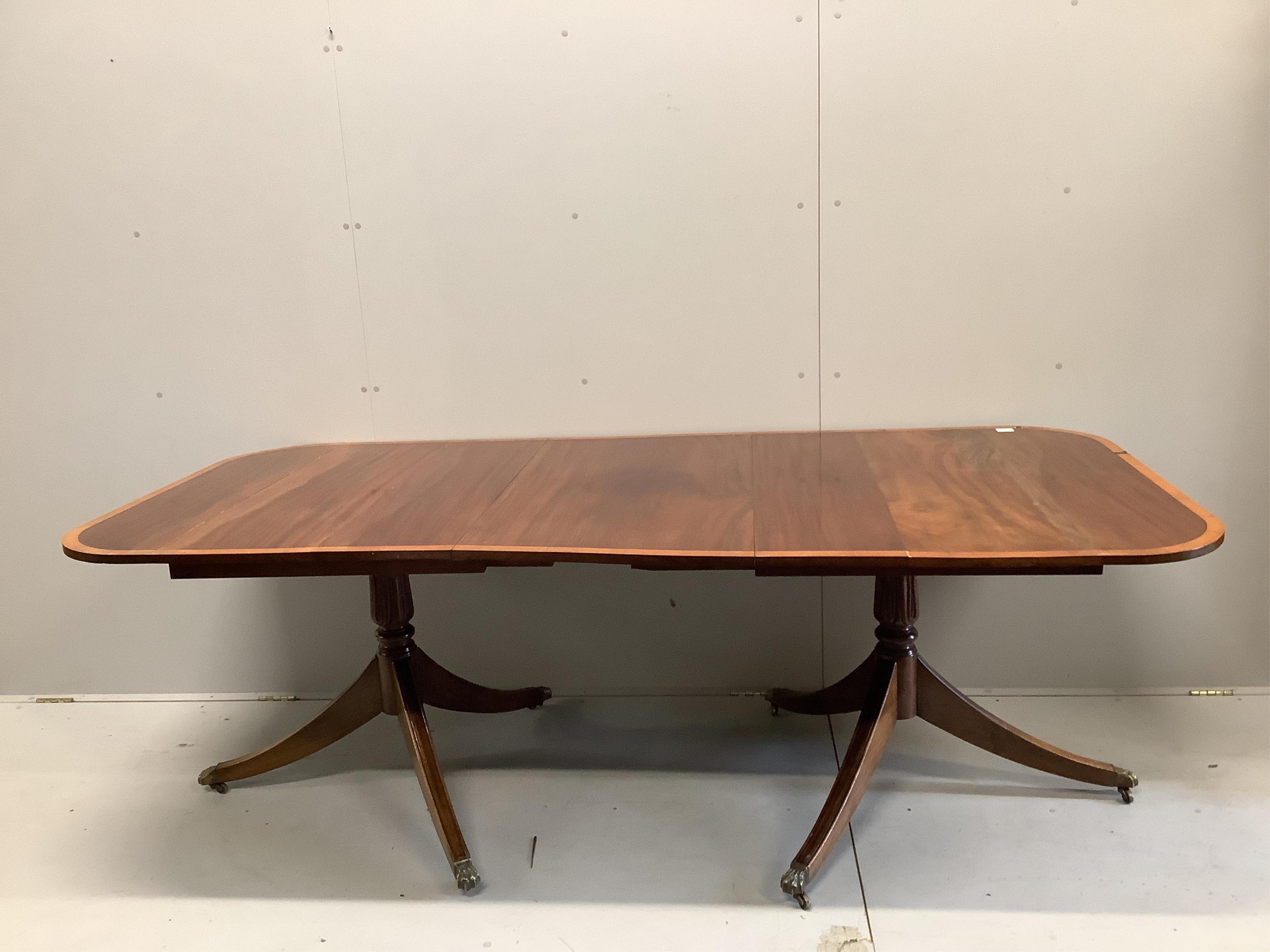 A George IV satinwood banded mahogany twin pedestal dining table, 223cm extended, one spare leaf, depth 106cm, height 74cm. Condition - fair to good